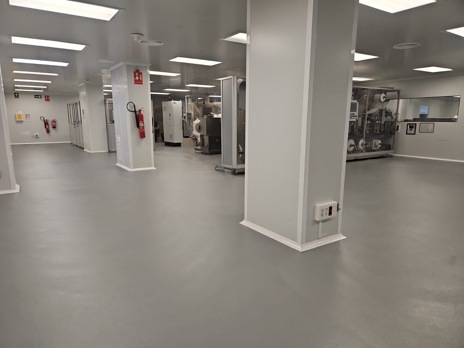 Pavimento multicapa de resina epoxi 100% sólidos en zona de empresa farmacéutica